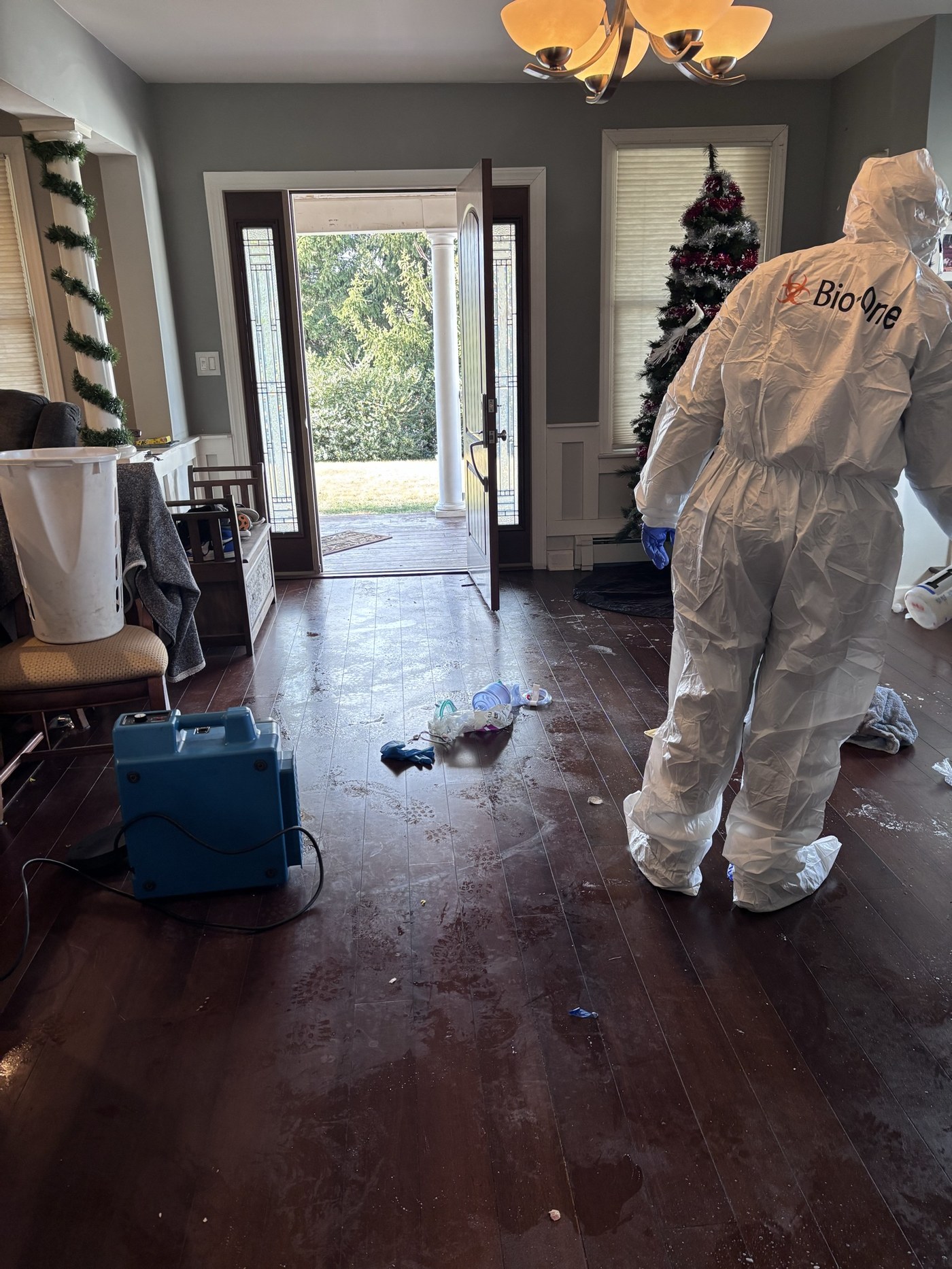 Certified biohazard technician performing remediation with air scrubber running.